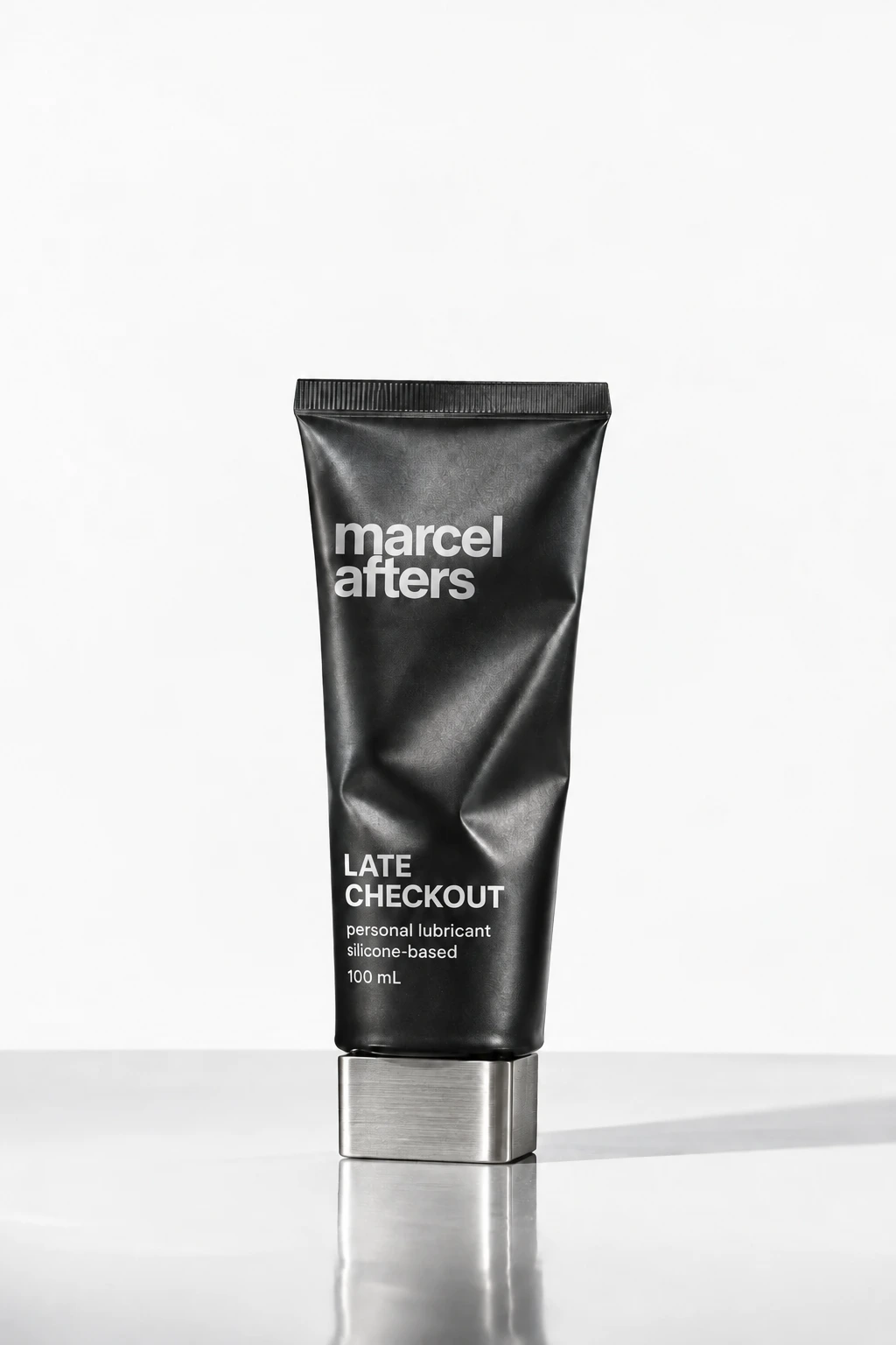 Late Checkout silicone-based concept, a black folded-metal tube with a silver cap, 100 mL