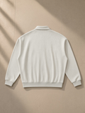 Heavyweight fleece polo sweatshirt in Oat Gray, laid flat on pale limestone, back view