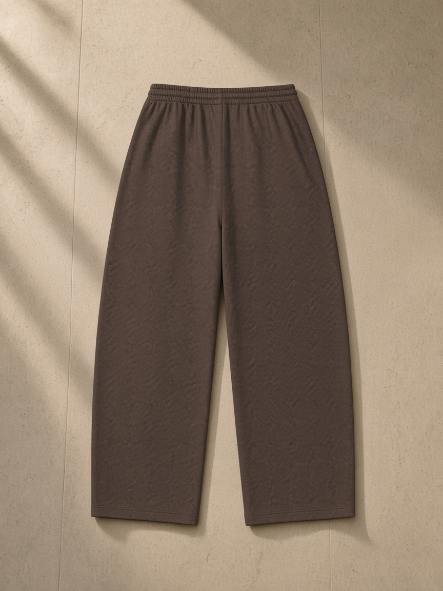 Waffle barrel leg pants in Coffee, laid flat on pale limestone, back view
