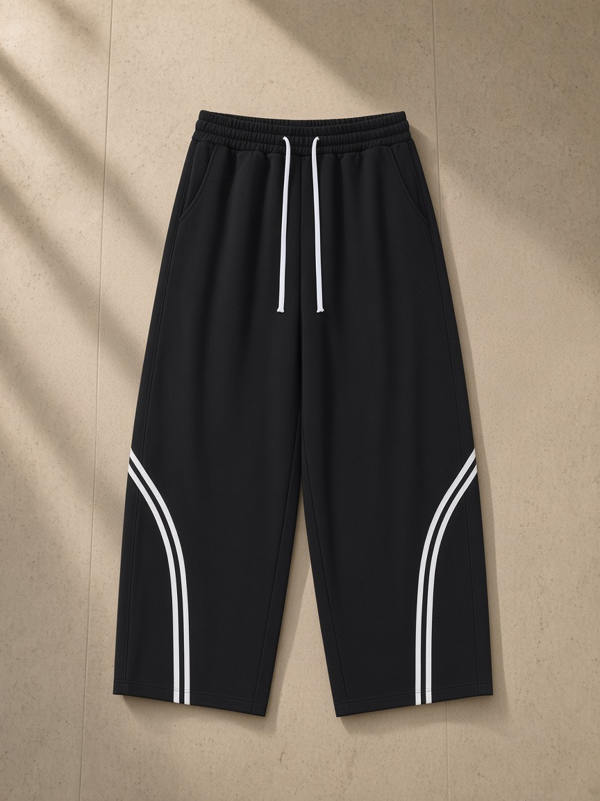 Wide Leg Piping Sweatpants in Black, laid flat on pale limestone