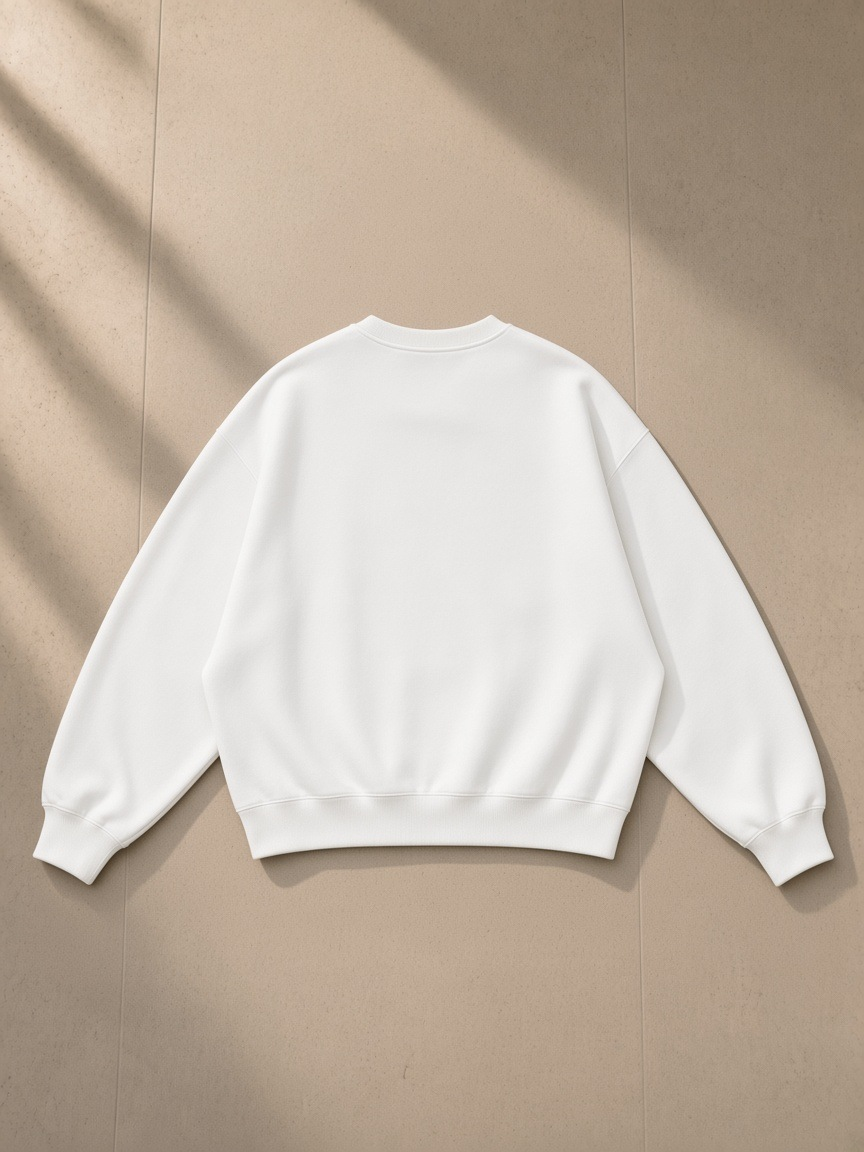 Essential Heavyweight Dolman Sleeve Boxy Sweatshirt in White, laid flat on pale limestone, back view