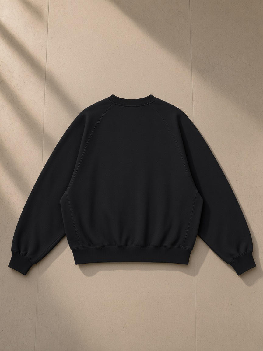 Essential Heavyweight Dolman Sleeve Boxy Sweatshirt in Black, laid flat on pale limestone, back view