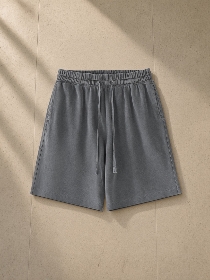 Vintage wash cotton shorts in Gray, laid flat on pale limestone