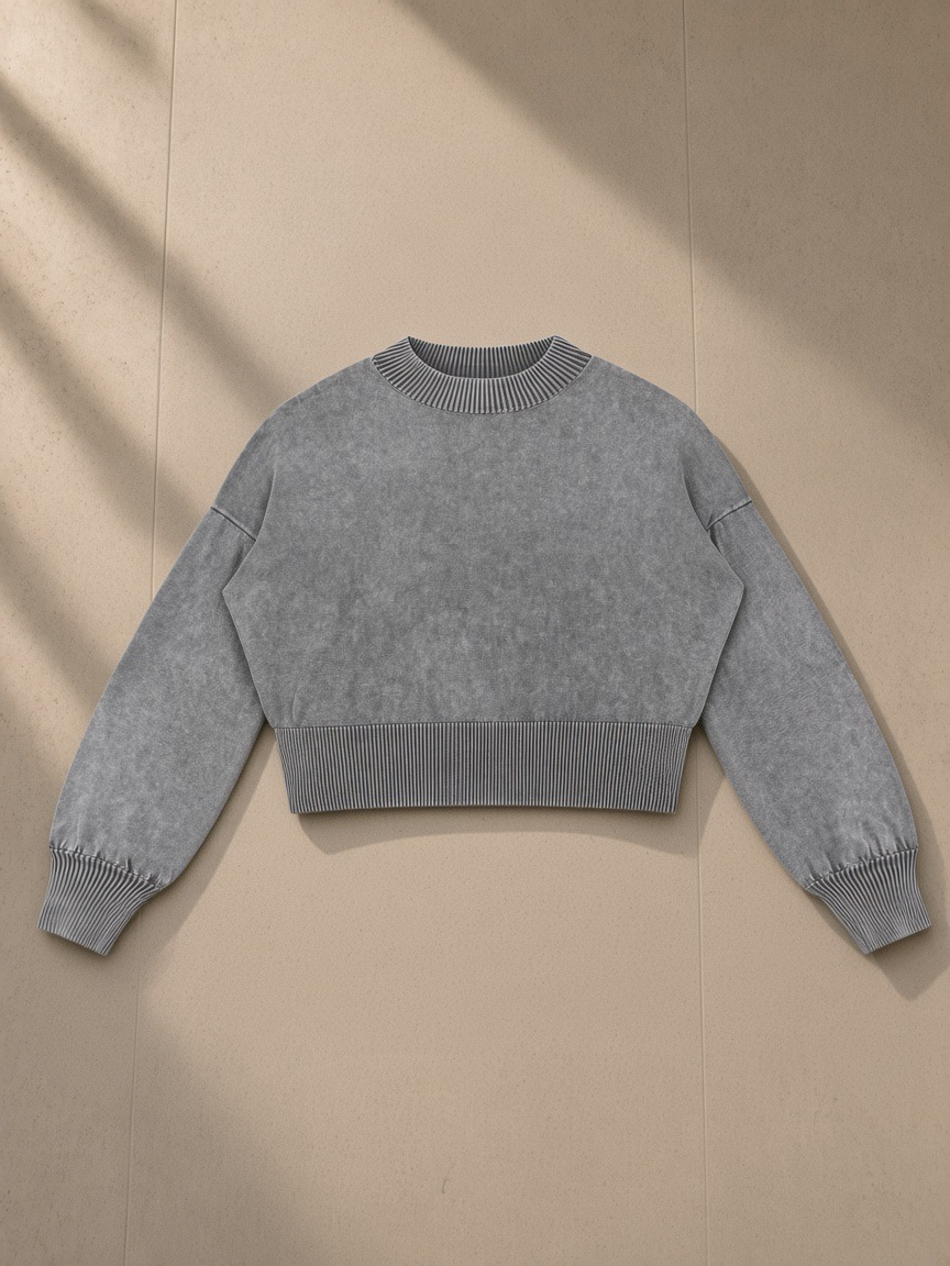 Women's Balloon Sleeve Cropped Sweater in Gray, laid flat on pale limestone