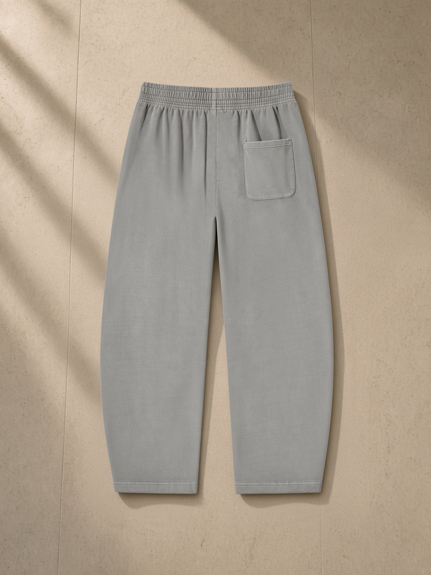 Vintage Washed Barrel Leg Sweatpants in Light Gray, laid flat on pale limestone, back.