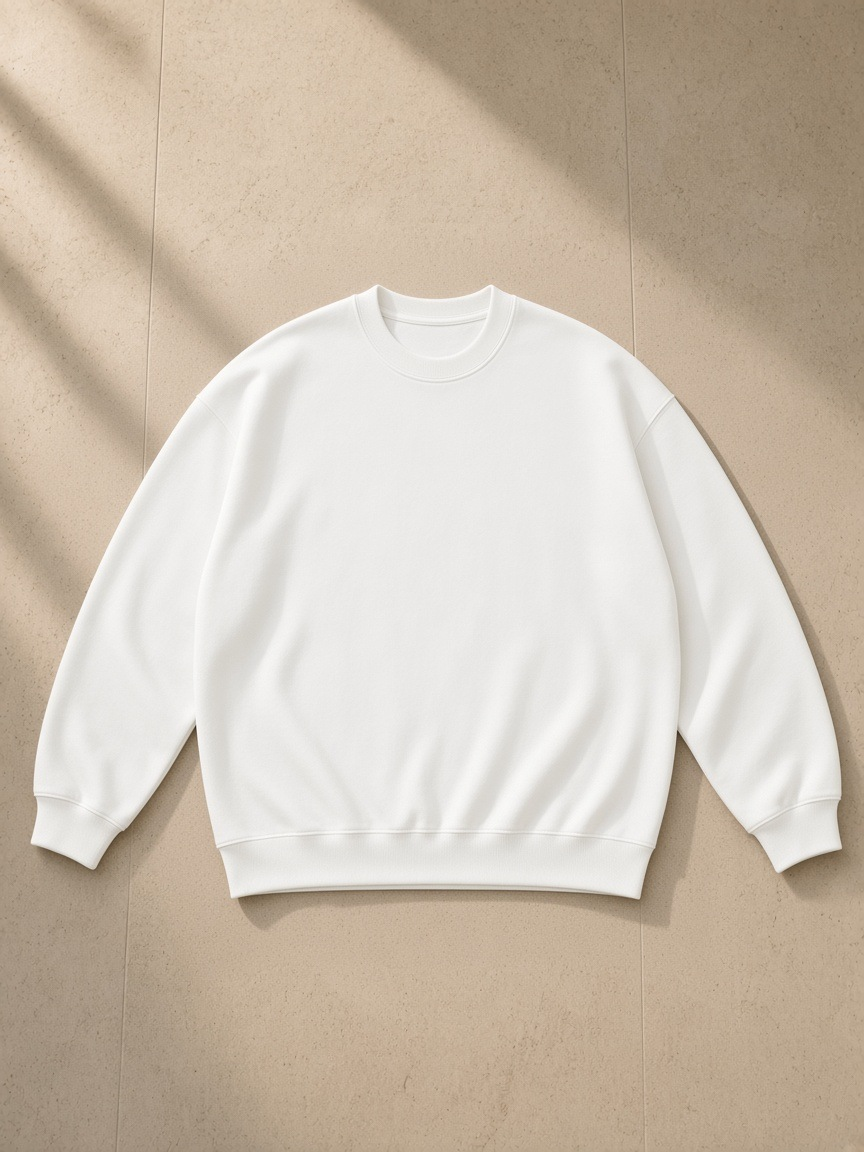 Oversized Drop Shoulder Crewneck Sweatshirt in White, laid flat on pale limestone, front.