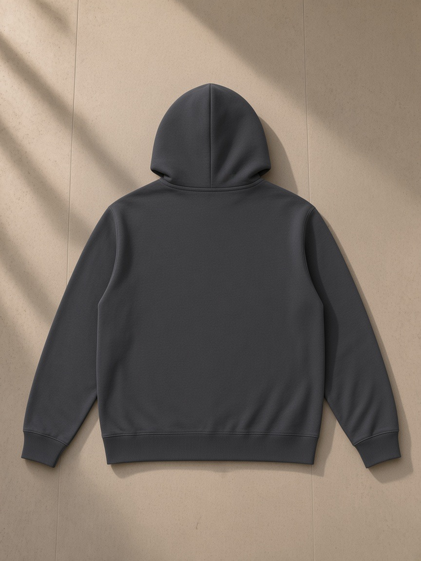 Essential oversized hoodie in Dark Gray, laid flat on pale limestone, back view
