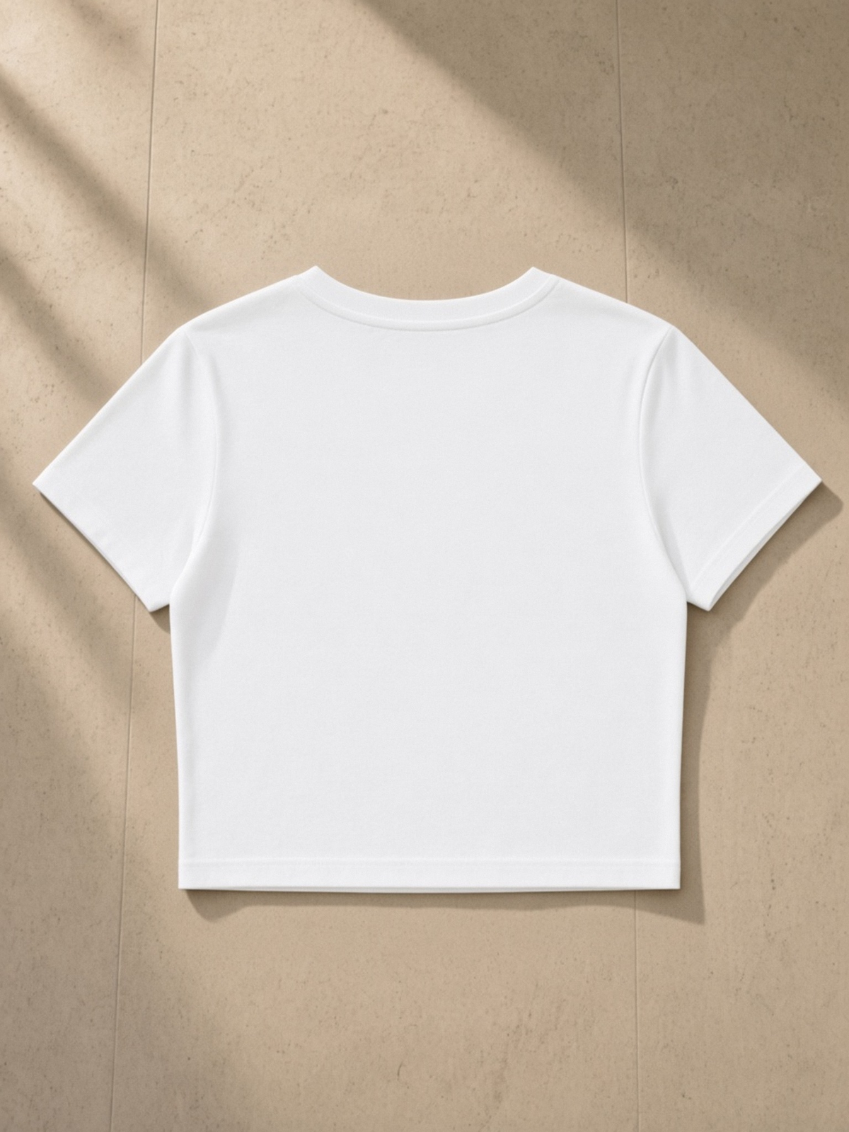 Fitted Crop Cotton T-Shirt in Lucent White, laid flat on pale limestone, back.