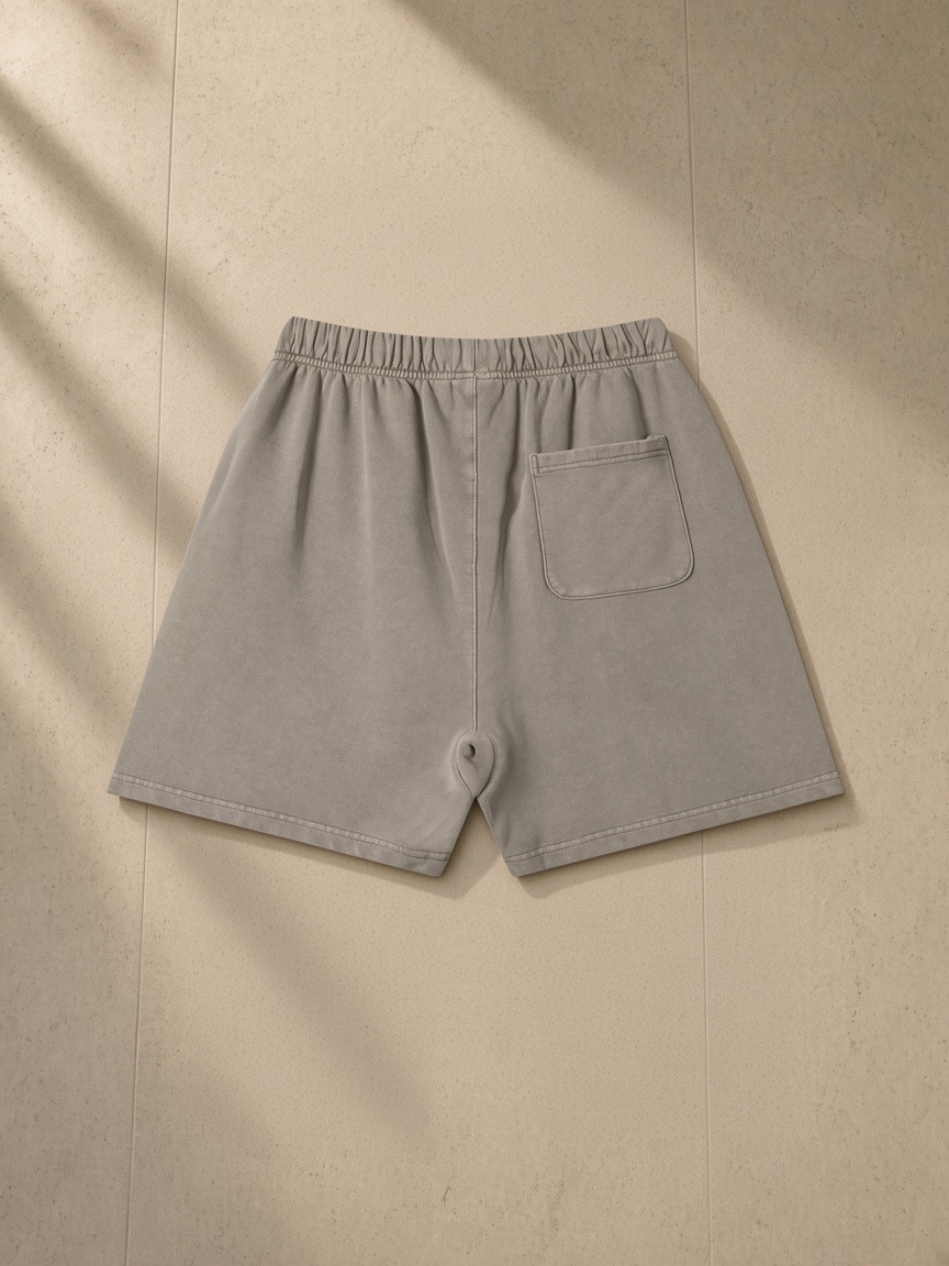 Vintage Wash Cotton Shorts, 360 gsm in Light Coffee, laid flat on pale limestone, back.