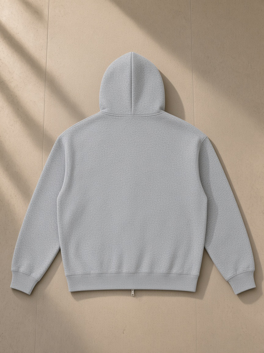 Essential heavyweight pocket hoodie in Flower Gray, laid flat on pale limestone, back view
