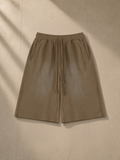 Unisex sunfade raw edge shorts in Coffee, laid flat on pale limestone