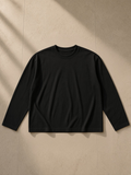Sunfade boxy long sleeve t-shirt in Black, laid flat on pale limestone