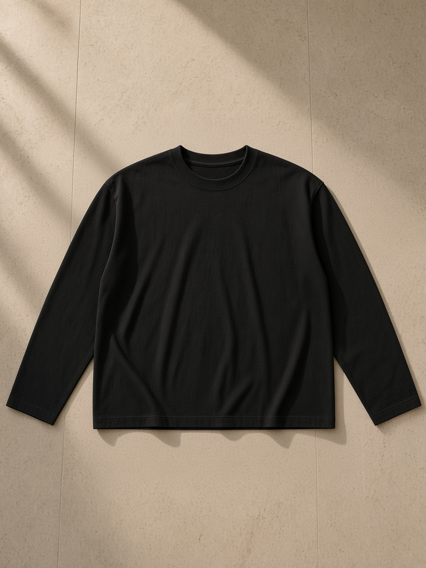 Sunfade boxy long sleeve t-shirt in Black, laid flat on pale limestone