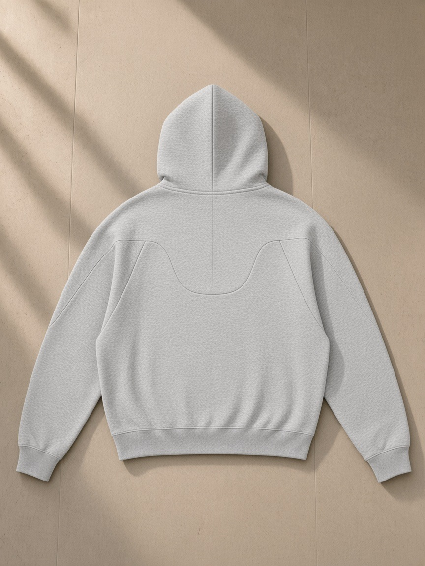 Curved panel raglan hoodie in Flower Gray, laid flat on pale limestone, back view
