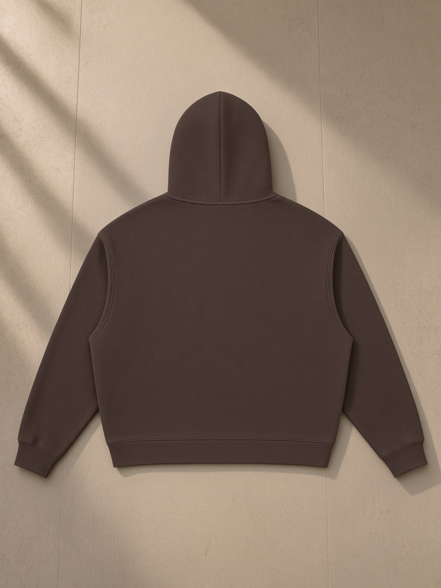 Waffle boxy hoodie in Coffee, laid flat on pale limestone, back view