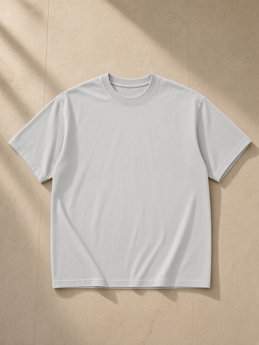 Enzyme Washed T-Shirt in Medium Ash, laid flat on pale limestone