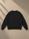 Unisex oversized v-neck sweatshirt in Black, laid flat on pale limestone, back view