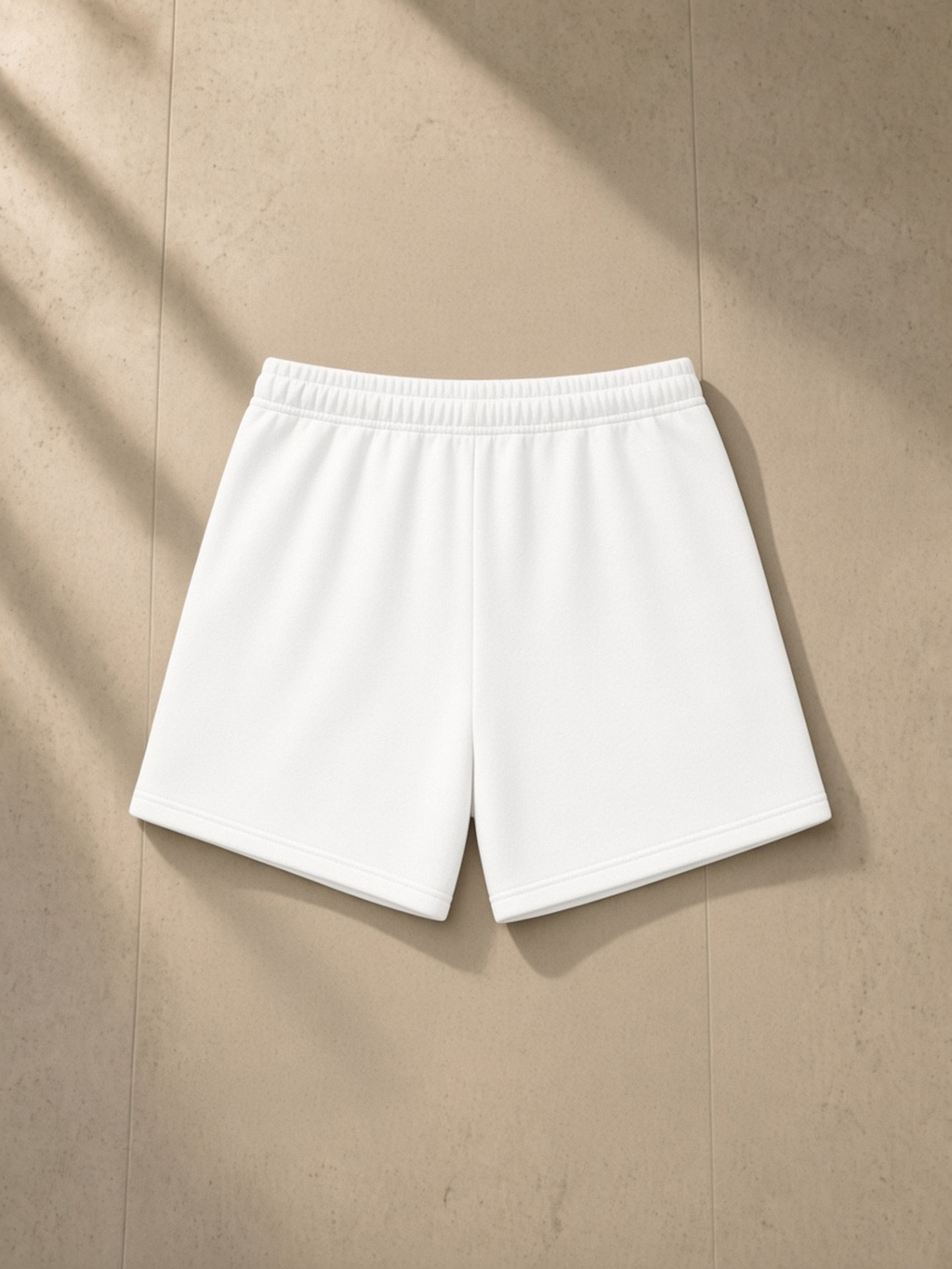 Essential Fleece Drawstring Sweatshorts in White, laid flat on pale limestone, back.