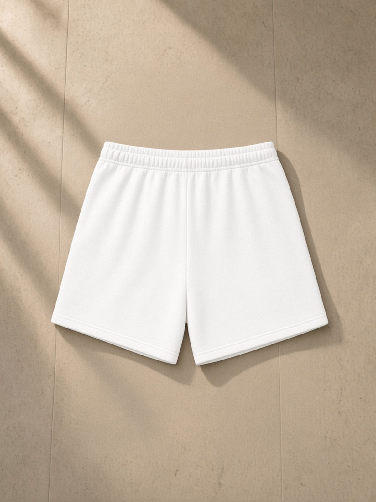 Essential Fleece Drawstring Sweatshorts in White, laid flat on pale limestone, back.