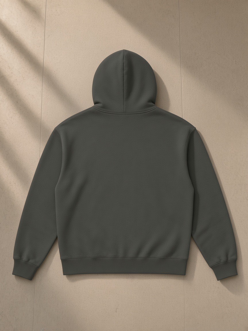 Heavyweight pullover hoodie in Dark Gray, laid flat on pale limestone, back view