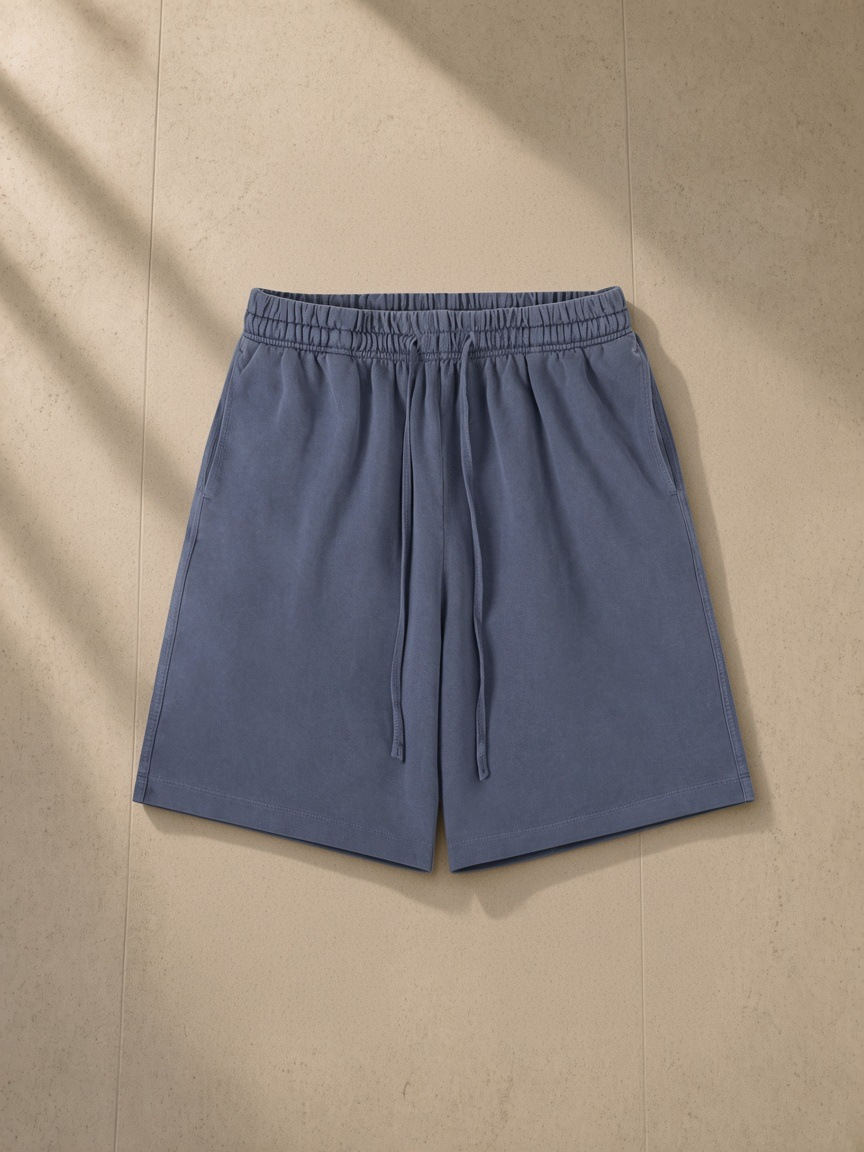Vintage wash cotton shorts in Navy Blue, laid flat on pale limestone