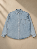 Vintage Wash Denim Shirt in Blue, laid flat on pale limestone