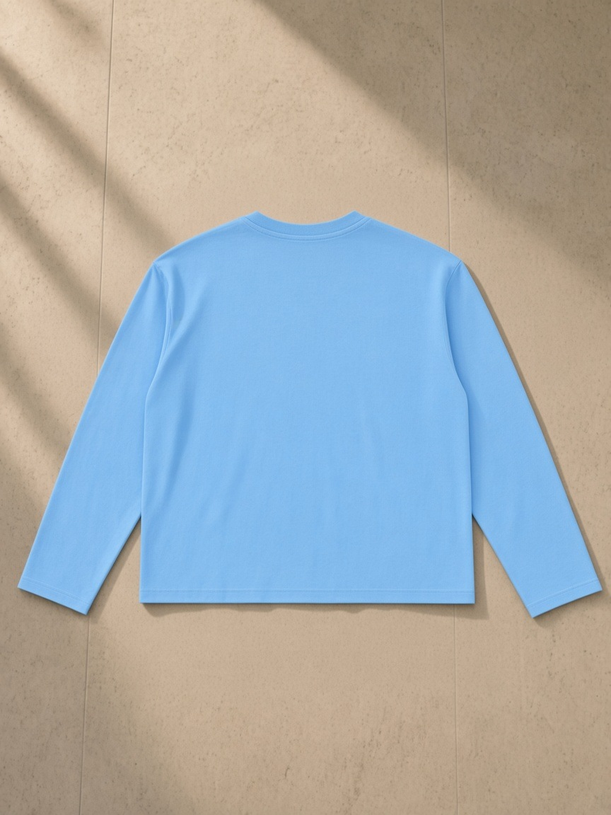 Vintage Wash Long Sleeve Boxy T-Shirt in Sky Blue, laid flat on pale limestone, back.