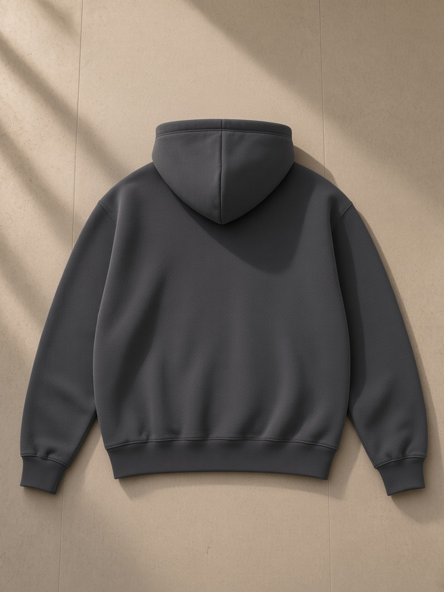 Unisex heavyweight fleece hoodie in Charcoal Gray laid over a marble vanity stool in a Montana ranch lodge at night