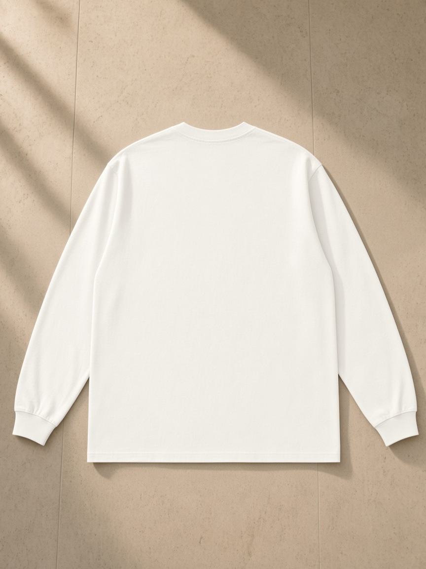 Raw Hem Long Sleeve T-Shirt in White, laid flat on pale limestone, back.