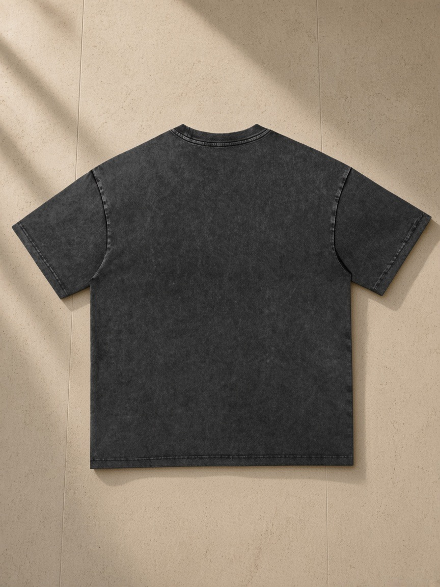 Women's Snow Washed Heavyweight Oversize T-Shirt in Black, laid flat on pale limestone, back.