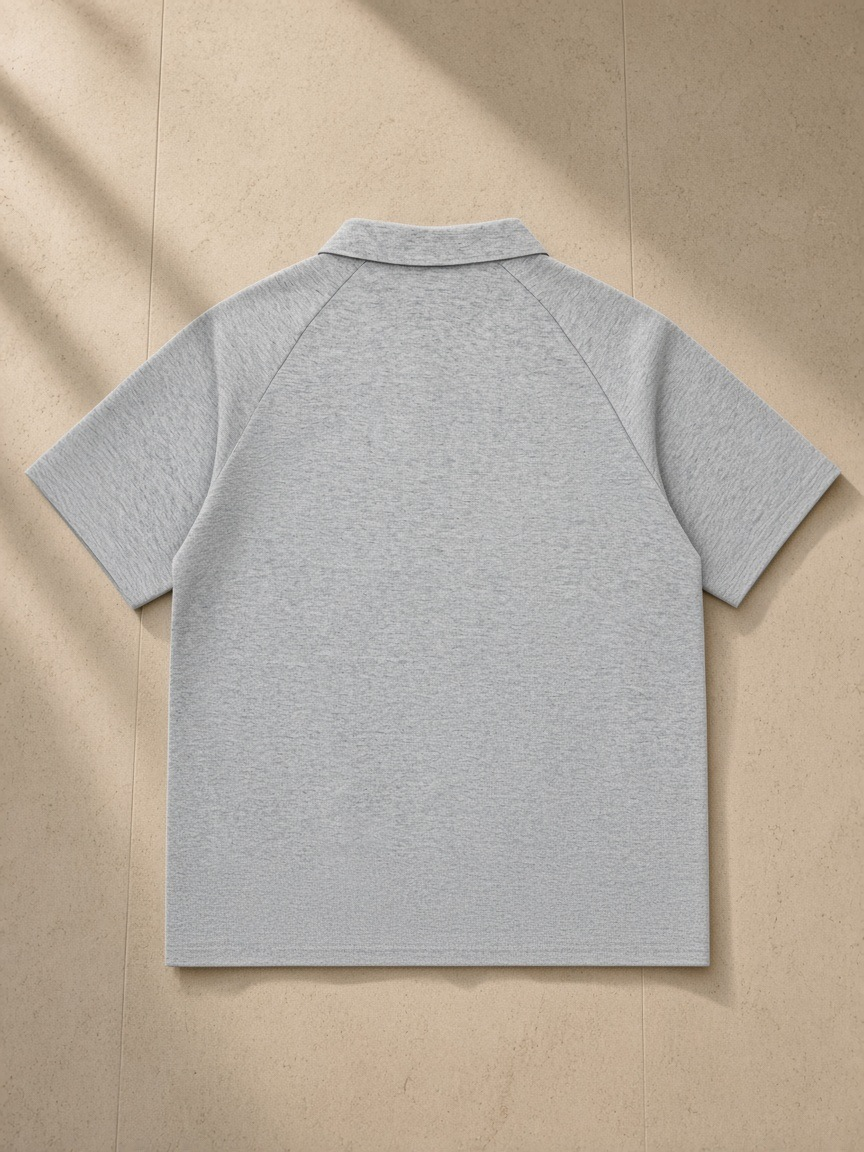 Classic Knit Polo in Flower Gray, laid flat on pale limestone, back view