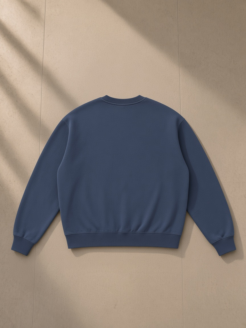 Boxy Vintage Washed Sweatshirt in Navy Blue, laid flat on pale limestone, back view