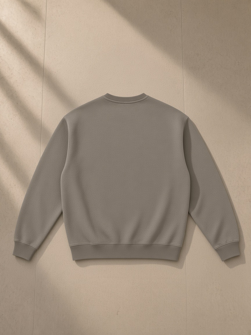 Fleeced sweatshirt in Gray Coffee, laid flat on pale limestone, back view