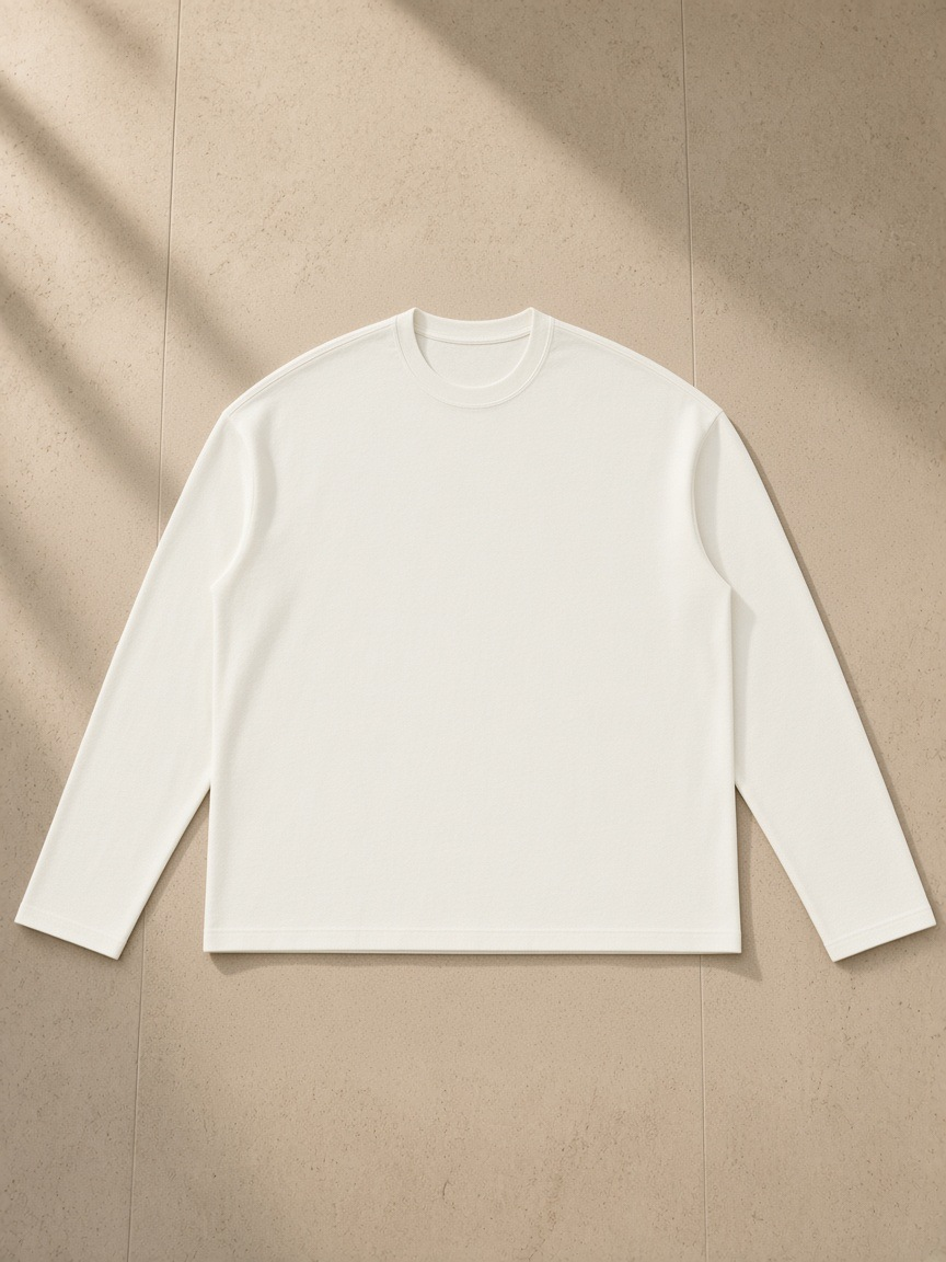 Raw Edge Long Sleeve T-Shirt in White, laid flat on pale limestone