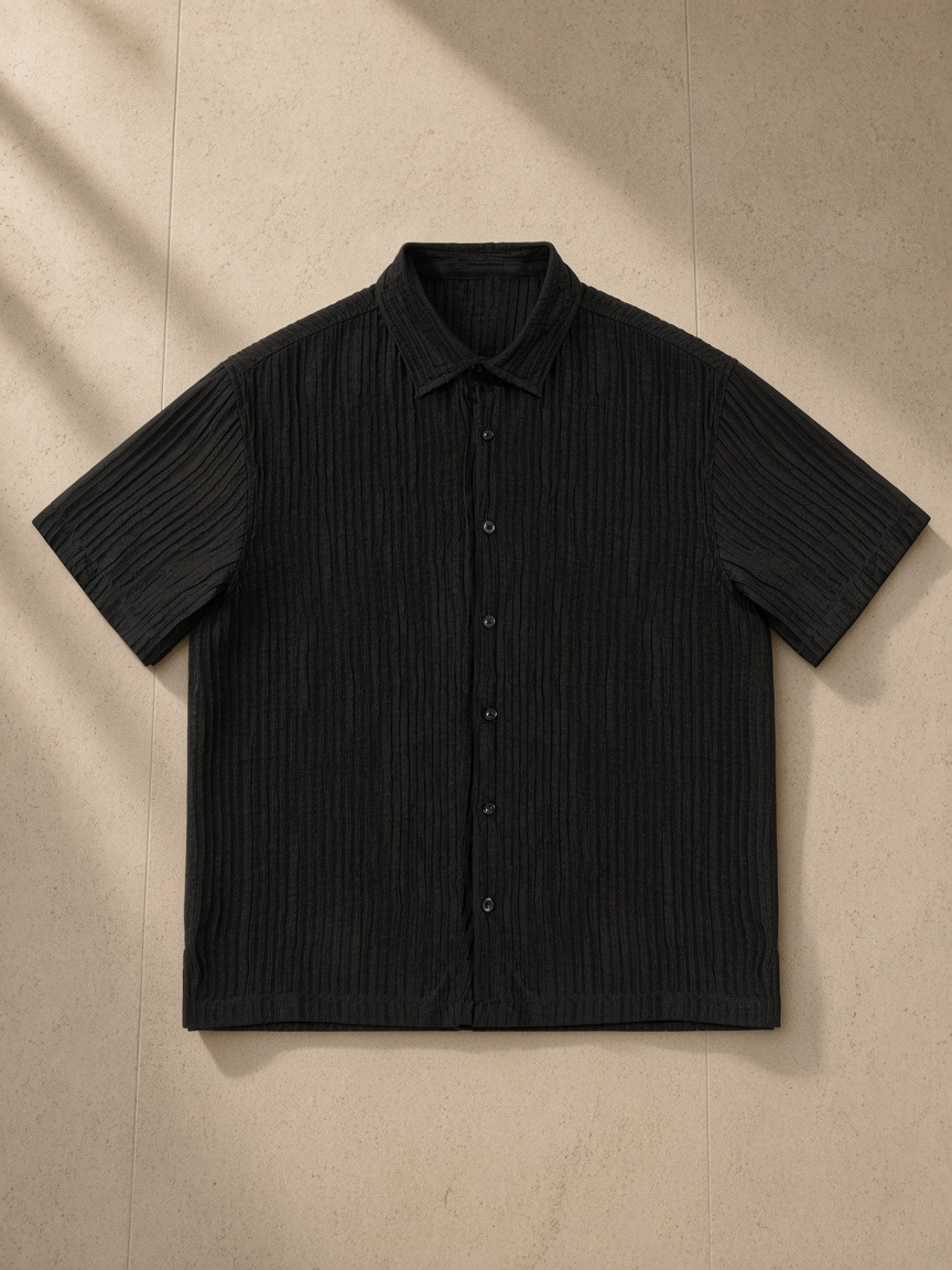 Tencel Jacquard Shirt in Black, laid flat on pale limestone