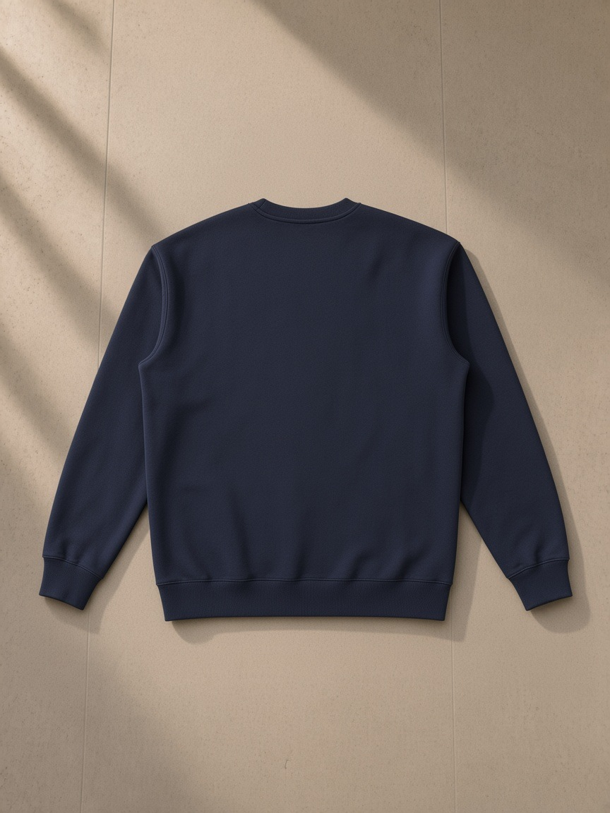 Essential heavyweight crewneck sweatshirt in Navy Blue, laid flat on pale limestone, back view
