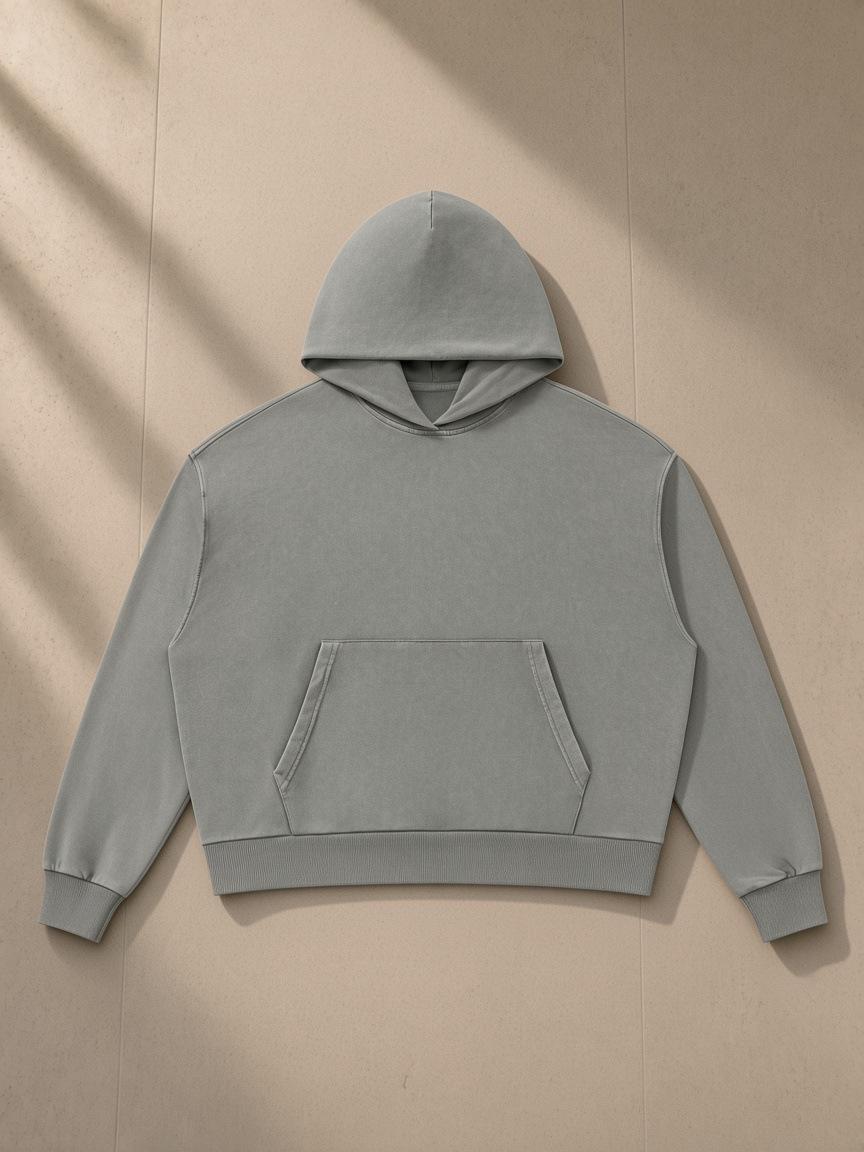Mineral Wash Boxy Hoodie in Light Gray, laid flat on pale limestone