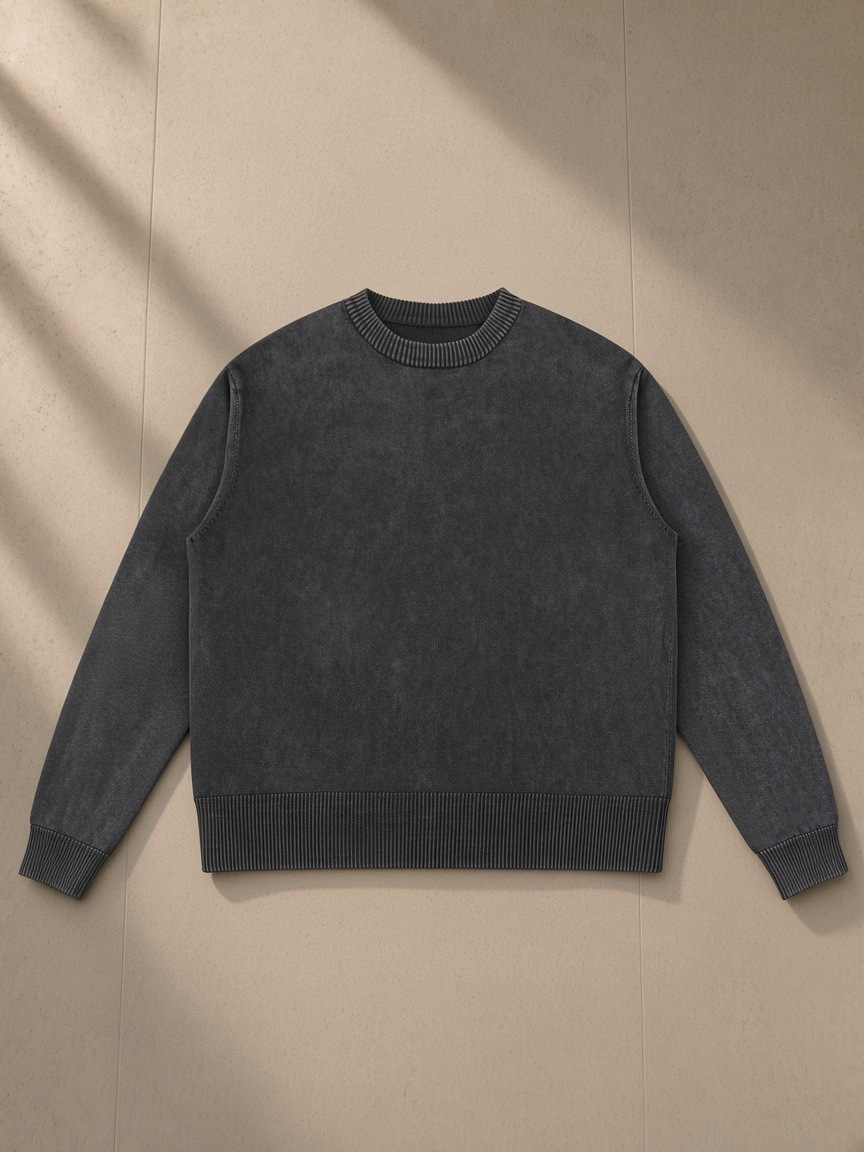 Mineral Wash Crewneck Sweater in Black, laid flat on pale limestone