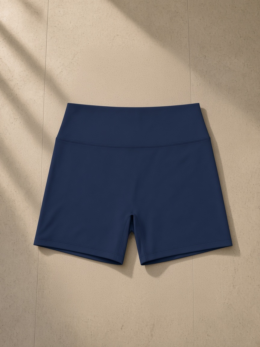 Women's High Rise Yoga Shorts in Navy Blue, laid flat on pale limestone