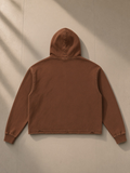 Vintage washed frayed-hem hoodie in Brown, laid flat on pale limestone, back view