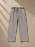 Unisex snow wash heavyweight sweatpants in Light Gray, laid flat on pale limestone