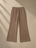 Vintage washed flared fleece pants in Coffee, laid flat on pale limestone