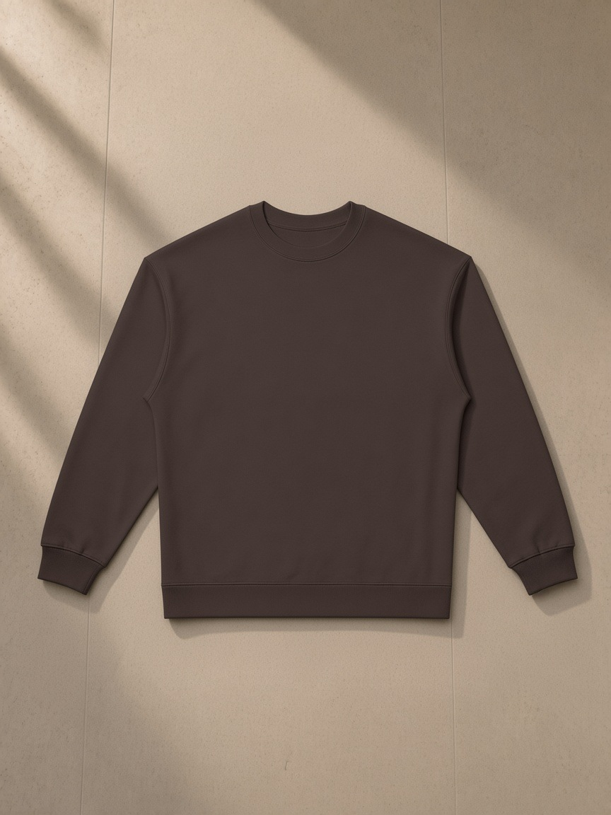 Oversized Crewneck Sweatshirt in Dark Brown, laid flat on pale limestone