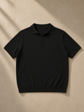 Unisex Heavyweight Oversized Polo Shirt in Black, laid flat on pale limestone