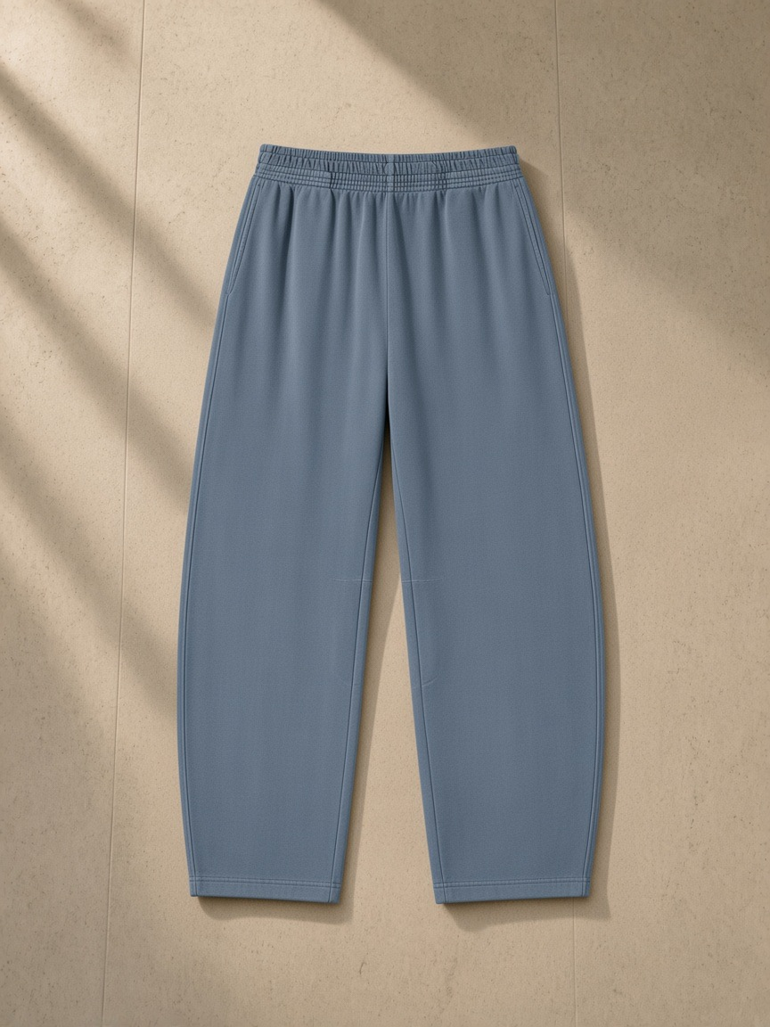 Vintage washed barrel leg sweatpants in Gray Blue, laid flat on pale limestone