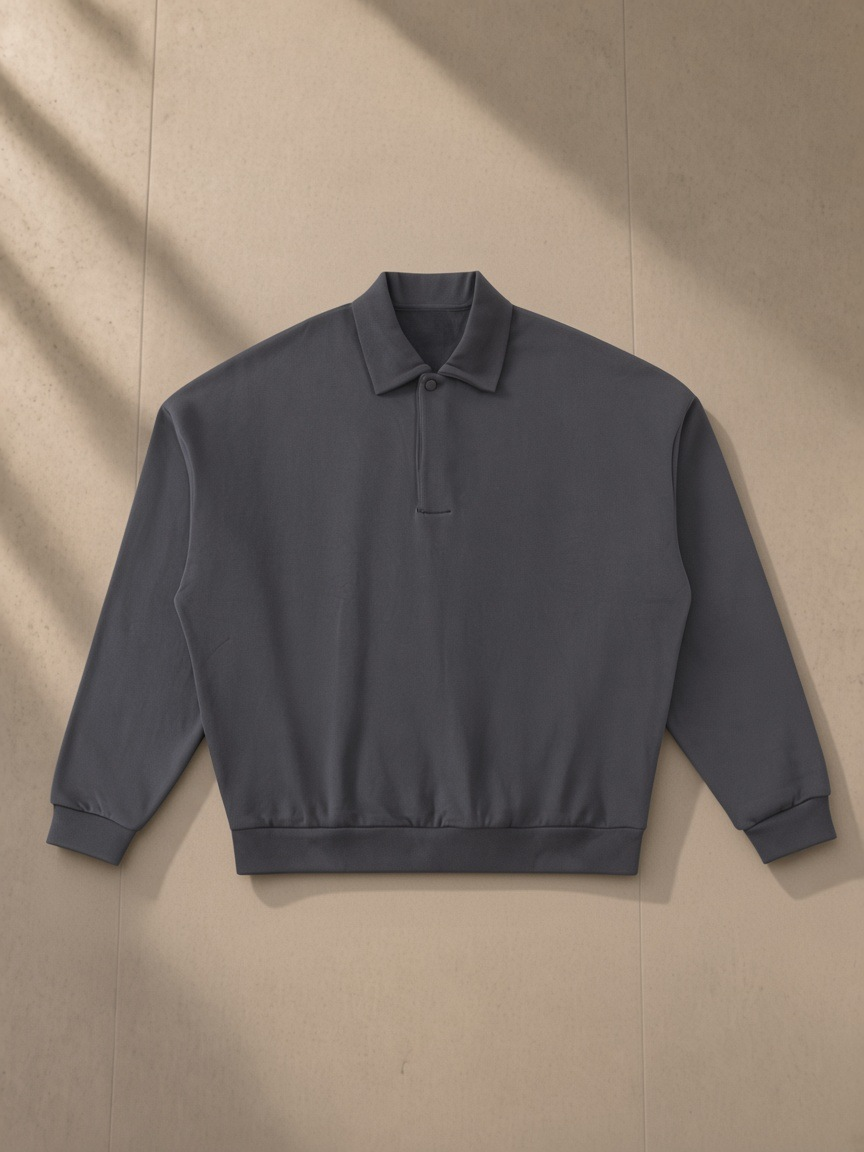Heavyweight Fleece Polo Sweatshirt — Dark in Charcoal Gray, laid flat on pale limestone, front.