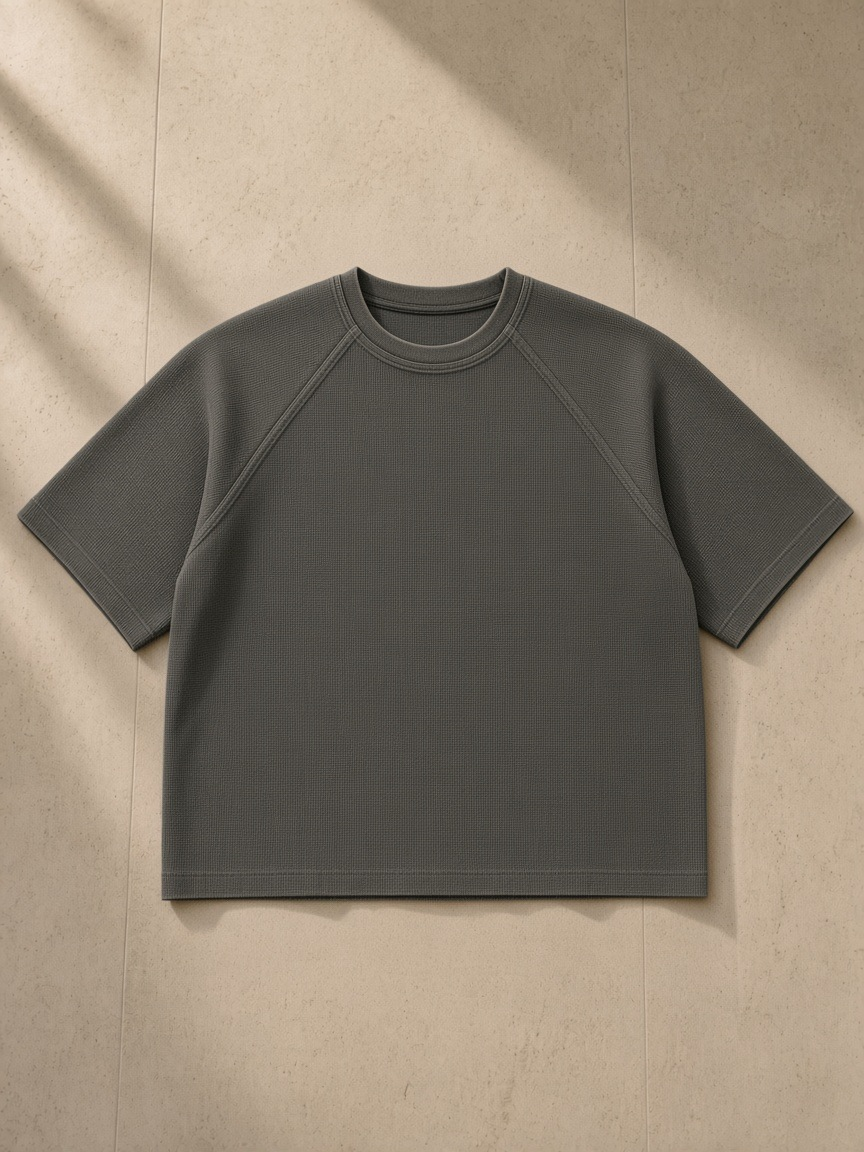 Unisex mineral wash boxy waffle t-shirt in Gray, laid flat on pale limestone
