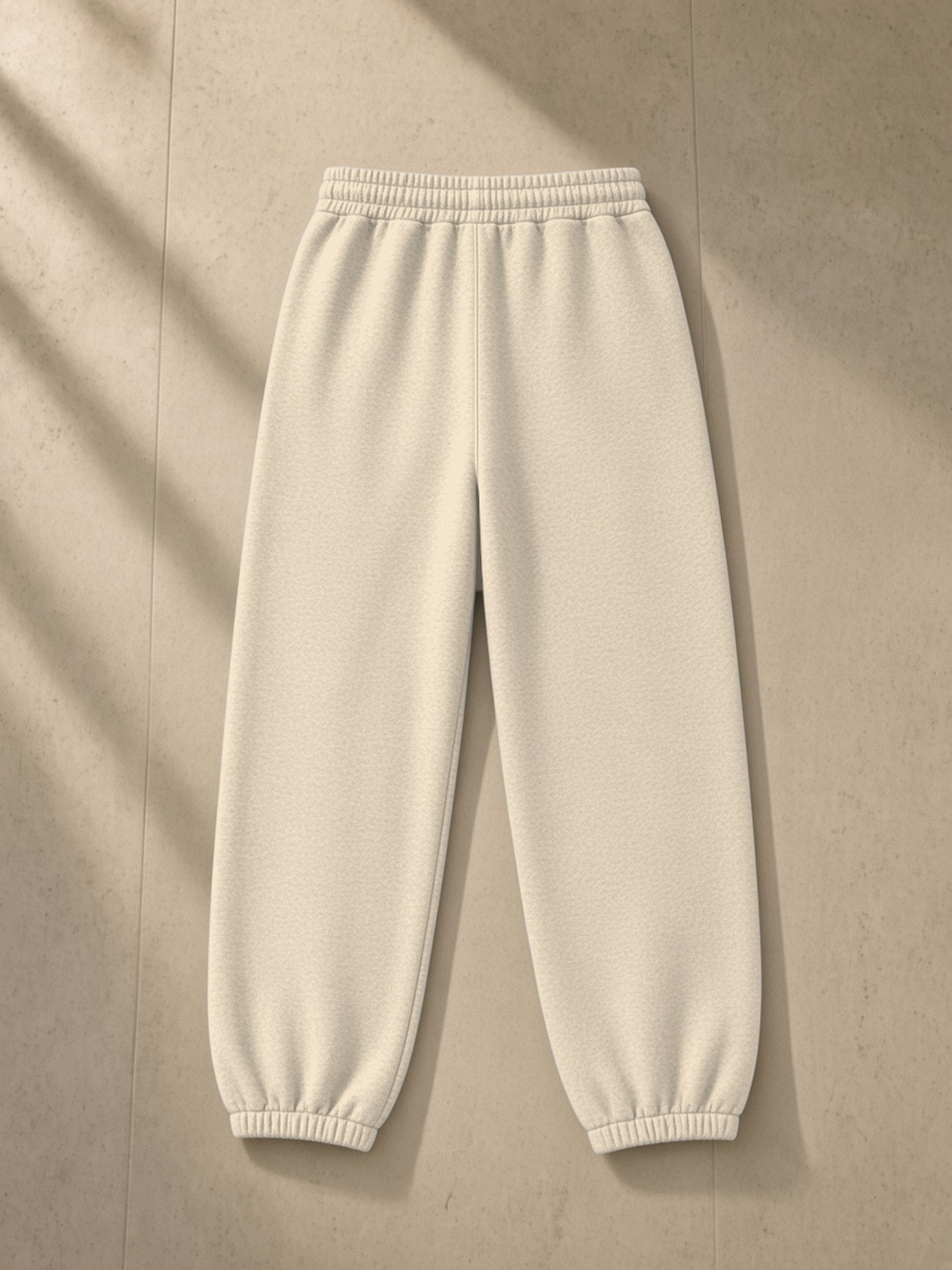 Vintage Washed Fleece Jogger Sweatpants in Apricot, laid flat on pale limestone, back.