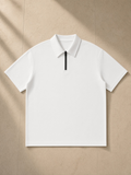 Quarter-Zip Knit Polo in White, laid flat on pale limestone