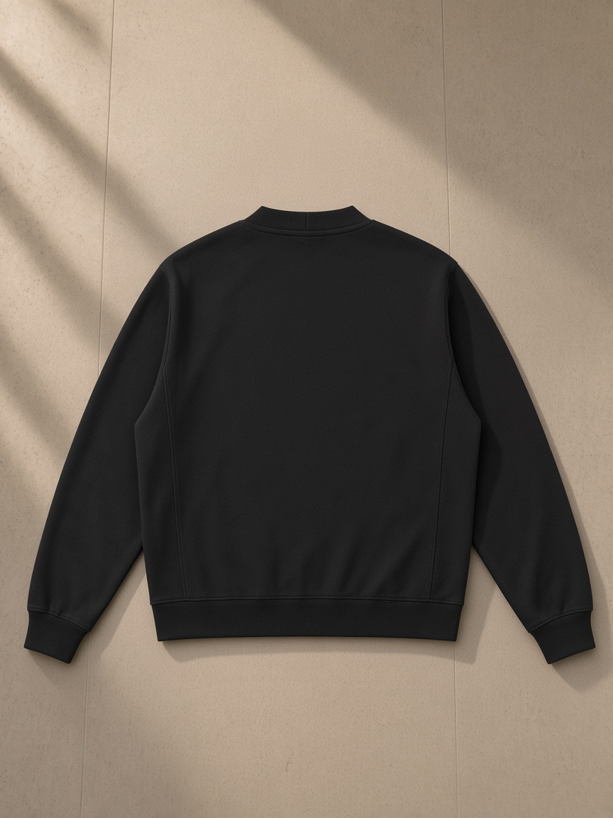 Heavyweight sweat cardigan in Black, laid flat on pale limestone, back view